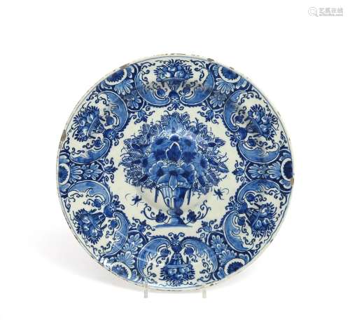 A Delft charger early 18th century, the well with a raised roundel, painted in blue with an