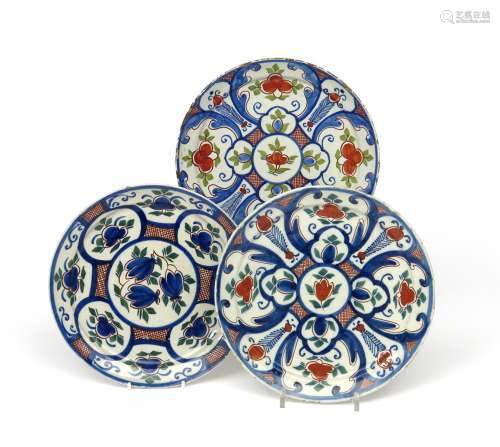Three London delftware plates c.1720, variously painted in red, green and blue with panels of
