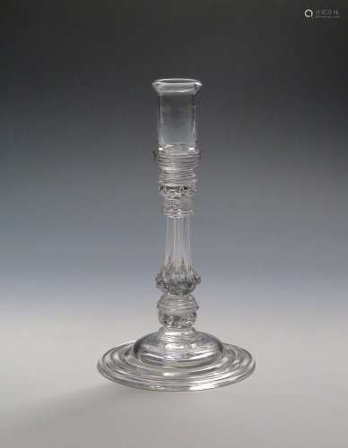 A glass candlestick c.1740, with tall cylindrical sconce rising to a folded rim, raised on a moulded