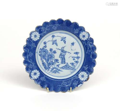 A Lambeth delftware scallop-edged plate c.1740-50, the well painted with a Chinese man carrying a