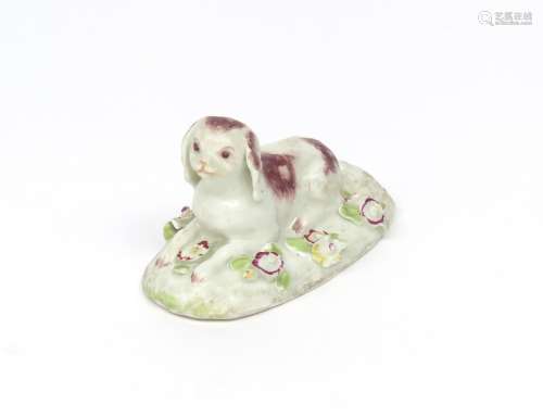 A rare Derby model of a spaniel c.1760, recumbent and facing forward on an oval base applied with