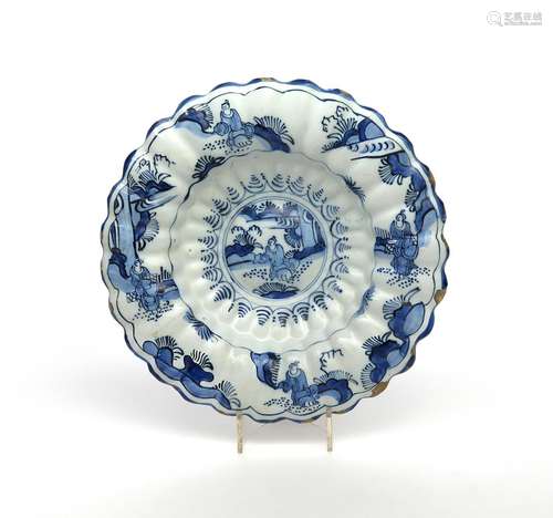 A Delft lobed dish c.1680, painted in blue with a Chinese figure seated in a garden setting, with