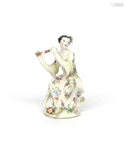 A Bow figure of a female musician c.1755-60, seated and playing the flute, wearing a flowered dress,