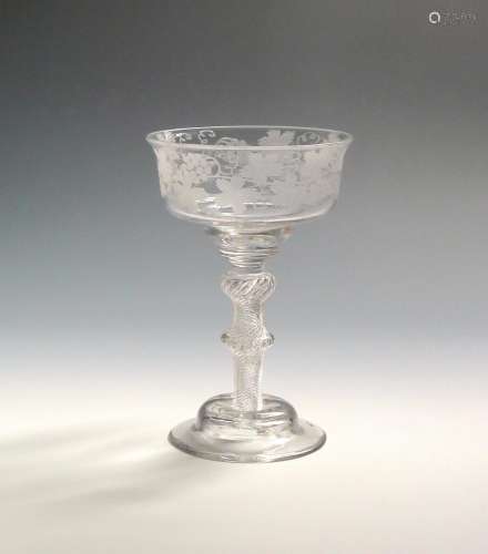 A fine champagne or mead glass c.1760, the wide ogee bowl engraved with a continuous band of