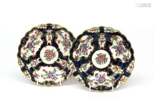 A pair of Worcester scallop edged plates c.1765, painted with panels of flower garlands reserved