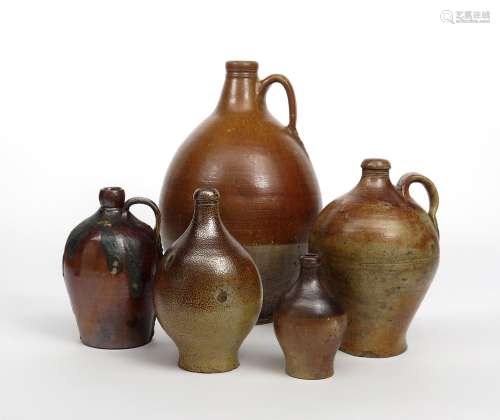 Five brown stoneware flagons 19th century and earlier, of varying ovoid form rising to short tapered