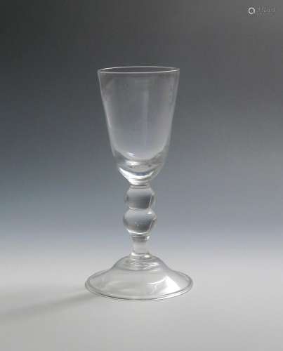 A toastmaster's goblet c.1740-50, the tall funnel bowl raised on a double-knopped baluster stem