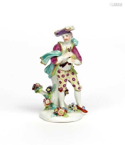 A Derby figure of a piping shepherd boy c.1760, standing on a low pad base applied with flowers, his