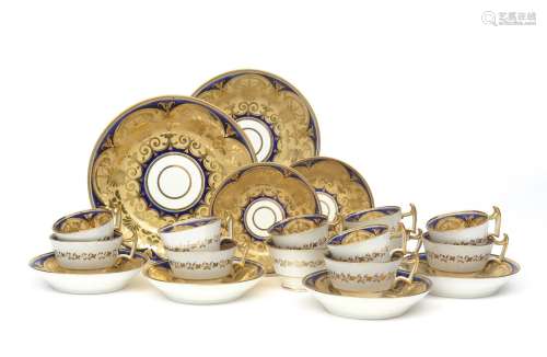 An English porcelain part tea service early 19th century, richly decorated with gilt foliate scrolls
