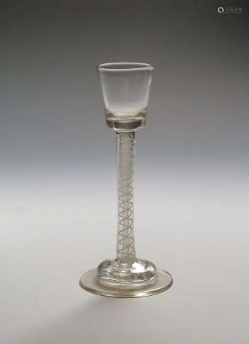 A cordial glass c.1755, the small flared bucket bowl raised on a tall double series opaque twist