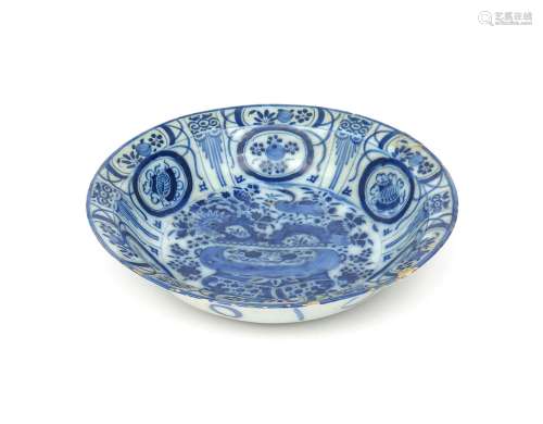 A large Delft dish late 17th/early 18th century, of deep circular form, painted in the Kraak