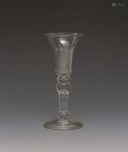 A light baluster wine glass c.1710, with a bell bowl over a flattened knop, the inverted baluster