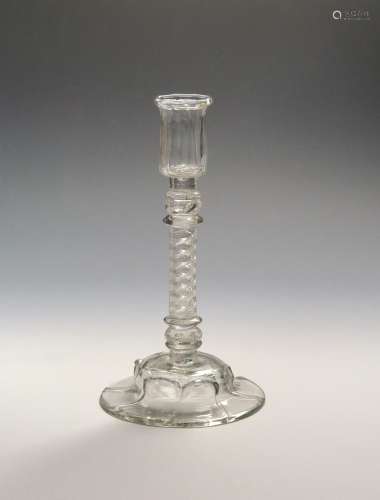 A rare glass candlestick c.1750, the ribbed cylindrical nozzle raised on a composite stem of a