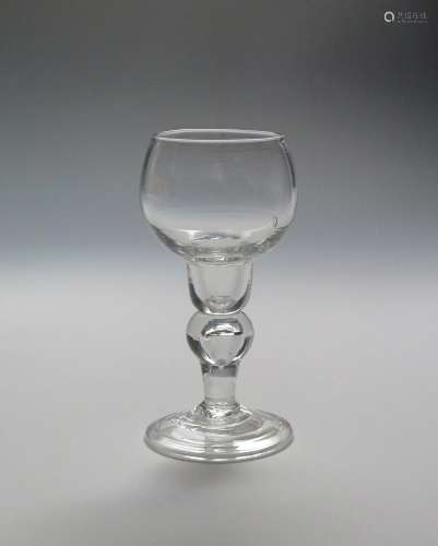 A rare cup-topped wine glass c.1720, rising from a narrow hollow base above an inverted baluster