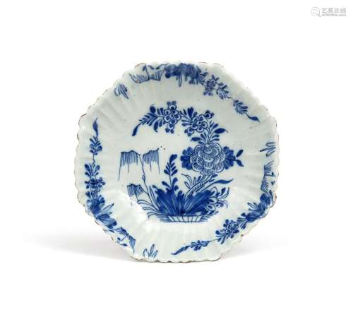 An unusual Delft saucer dish 18th century, of fluted octagonal form, painted in blue with peony