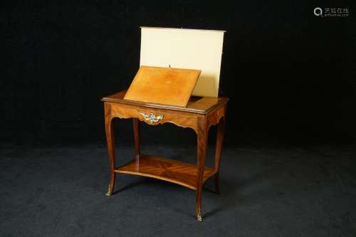 Table liseuse Louis XV. Elle présente une écritoir...