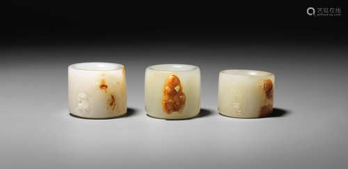 Mid-Qing Dynasty Three white and russet jade thumb rings