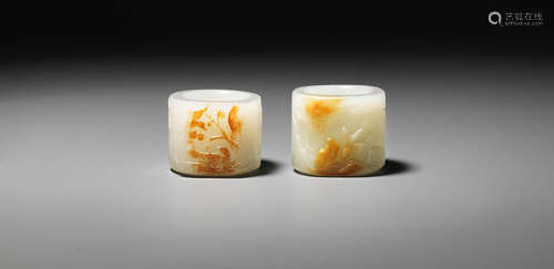 Mid-Qing Dynasty Two white and russet jade 'magpies' thumb rings