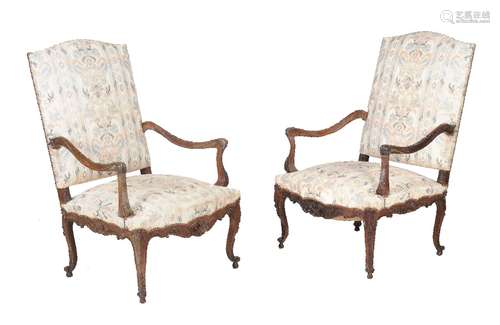 A pair of Continental carved walnut and upholstered armchairs