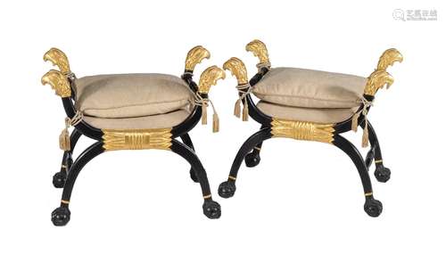 A pair of ebonised and parcel gilt x-frame stools in Regency style