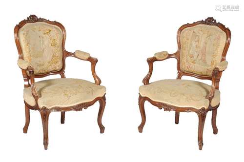 A pair of carved walnut and tapestry upholstered armchairs