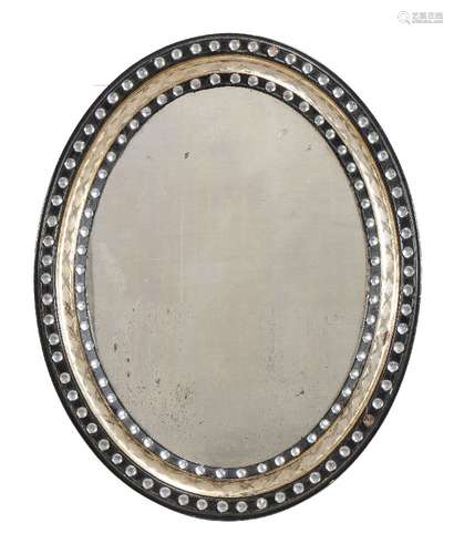 An ebonised and parcel gilt oval wall mirror in Irish Regency style