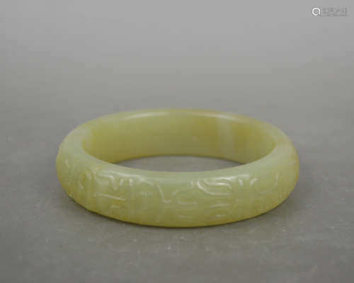A YELLOW JADE CARVED BANGLE