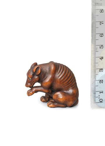 By Tomotada, Kyoto, Edo period (1615-1868), late 18th/early 19th century A wood netsuke of a wild dog (yama-inu)