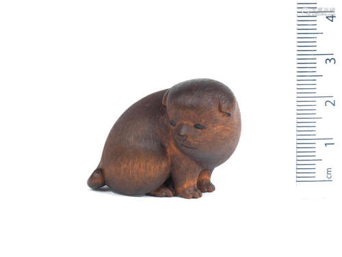 By Meikeisai Hojitsu, Edo/Tokyo, late 19th century A small wood netsuke of a puppy