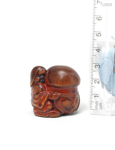 Early 19th century A small lacquered wood netsuke of Okame