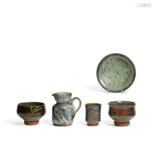 Group of Five Objectscirca 1955comprising a footed vase, a tea cup, a pitcher and two footed bowlsglazed stoneware, signed on the undersideheight of footed vase 4 1/2in (11cm); diameter 5 1/2in (13cm); height of tea cup 4in (10cm); diameter 3 1/4in (8cm); height of pitcher 6 1/4in (15cm); length over handle 6 1/4in (15cm); height of bowl 2in (5cm); diameter 7 1/2in (19cm); height of small footed bowl 4in (10cm); diameter 6in (15cm)  Peter Voulkos (1924-2002)