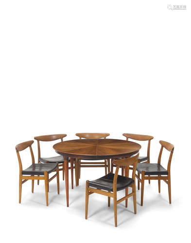 Extension Dining Table 1950steak, brass tag 'ILLUMS BOLIGHUS KOBENHAVN', with two leaves; together with a set of six Hans J. Wegner W2  dining chairs for C.M. Madsens, oak, stamped 'C.M. MADSENS FABRIKER HAARBY DANMARK MADE IN DENMARK DESIGN: HANS J. WEGNER'height of table 28 1/2in (72.5cm); diameter without leaves 46 1/2in (118cm); height of chairs 29 3/4in (75cm); width 21 3/4in (55cm); depth 17 1/4in (43cm) (9)  Danish Modern