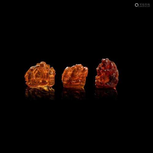 THREE AMBER 'IMMORTALS' CARVINGS QING DYNASTY, 19TH CENTURY largest 5cm high