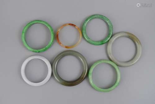 A GROUP OF SEVEN JADE, AGATE AND JADEITE BANGLES