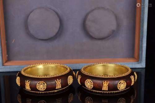 PAIR CHENXIANG WOOD AND GILT DECORATED BANGLES