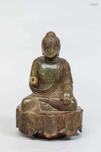 Buddha assis sur une base couverte du textile drap...