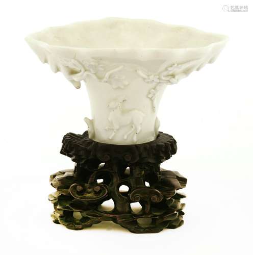 A Chinese blanc de Chine cup, 18th century, in the shape of a libation cup, moulded in relief with ...