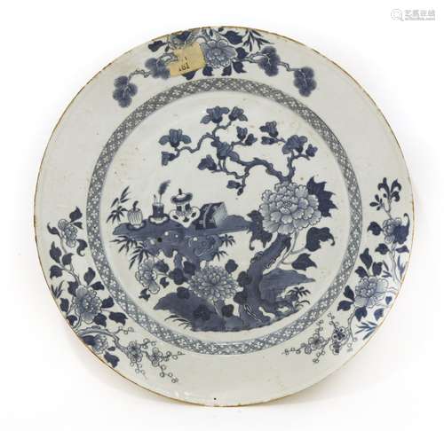 A Chinese blue and white charger, 18th century, painted with scholar's objects, including an ...