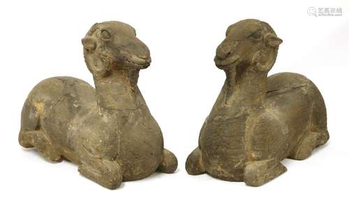 A large pair of Chinese wooden rams, probably Ming dynasty, each recumbent with their legs folded ...