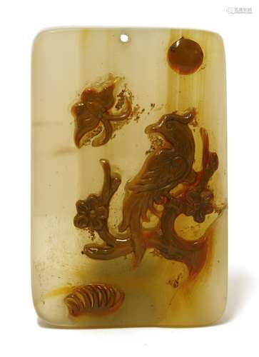 A Chinese agate pendant, of rectangular form, carved with a phoenix standing on a blossoming tree ...