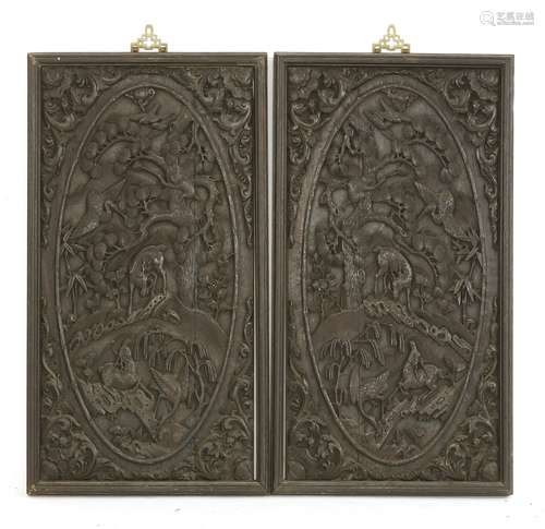 A pair of Chinese wooden panels, early 20th century, each carved with cranes and deer under a pine ...