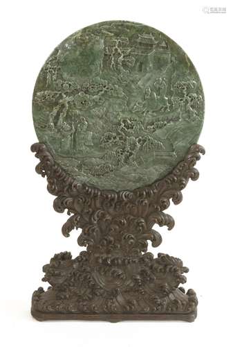 A Chinese jade plaque,  of circular form, carved with a scholar and attendants under pine trees, ...