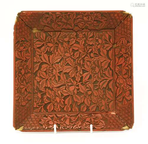 A cinnabar lacquered tray, 19th century, of circular form, deeply carved with peony and leaves, the ...