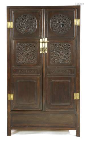 A Chinese hardwood cabinet,  early 19th century, the door panels pierced and carved with figures in ...