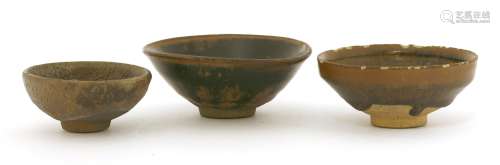 Three Chinese Jian ware tea bowls, Song Dynasty (960-1279), of conical form, the glaze falling ...