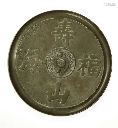 A Chinese bronze mirror, moulded with Chinese characters 'Shou Shan Fu Hai', the centre with a ...