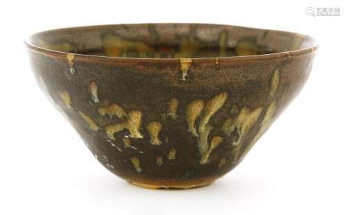 A Chinese tea bowl, in the style of Jizhou ware, the glaze of opaque and brown running to the foot ...