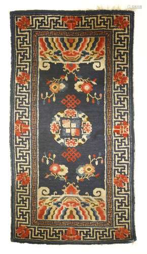 A Chinese mat, decorated with florets ascending from a rock above waves against a midnight blue ...