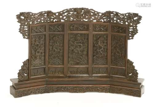 A Chinese wooden table screen, 19th/20th century, carved with dragons amongst clouds above waves in ...