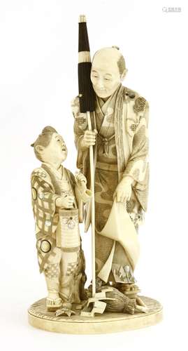 A Japanese ivory okimono, Meiji period (1868-1912), of a man clutching an umbrella, with a boy to ...